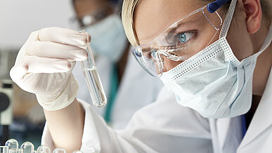 Frau mit Reagenzglas im Labor