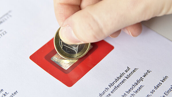 Letter with PIN cover and thumb with coin.