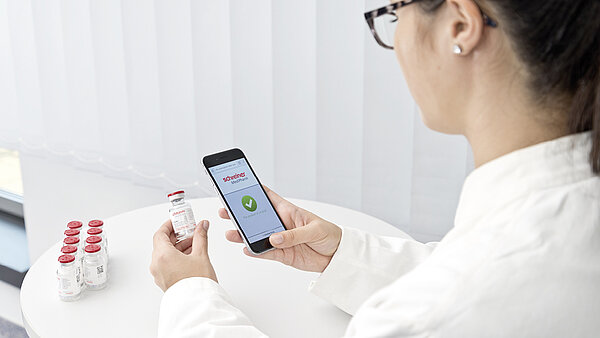 Woman uses a smartphone to check whether it is an original medicine.