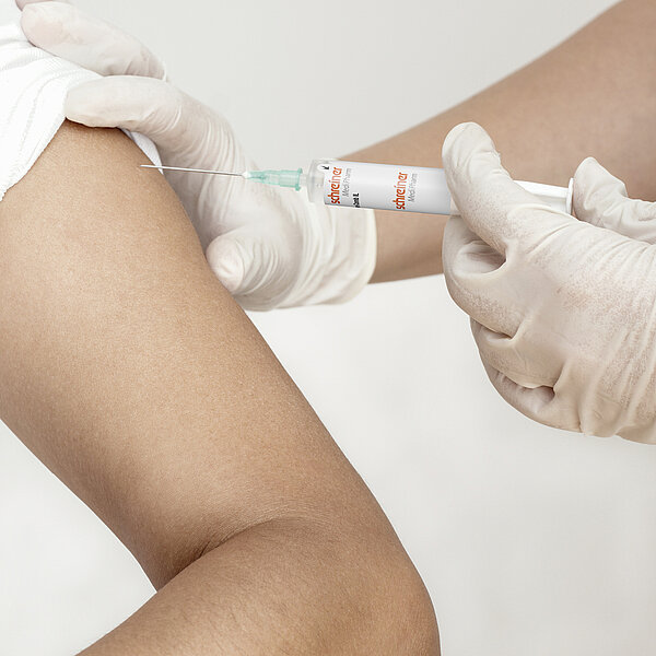 Medication administration into the upper arm with a syringe equipped with the documentation label Pharma-Comb.