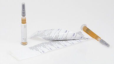 A two-ply label wrapped around the syringe blinds the investigational product contained within.