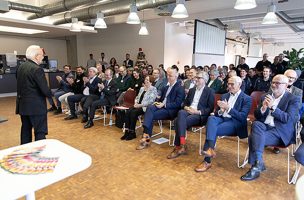 Seniorgesellschafter und Bauherr Helmut Schreiner trägt ein humorvolles Gedicht zur erfolgreichen Entwicklung am Standort Dorfen vor.