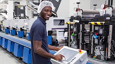 Auszubildender an einer Flexodruckmaschine