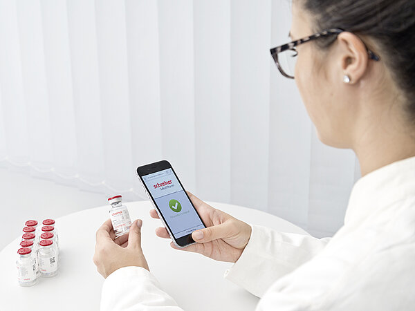 Woman uses a smartphone to check whether it is an original medicine.