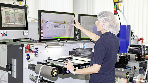 Woman checks on the monitor whether labels are error-free.