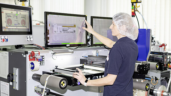 Woman checks on the monitor whether labels are error-free.