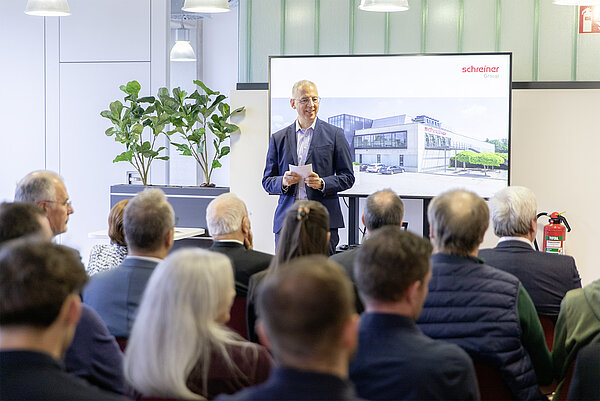 Eröffnung des Anbaus: Geschäftsführer Roland Schreiner begrüßt die Gäste, darunter Vertreter des Hauptsitzes Oberschleißheim, der Stadt Dorfen sowie Mitarbeiter des Standorts.