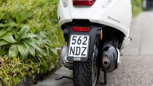 Motorroller mit selbstklebendem Folienkennzeichen auf Trägerplatte aus Kunststoff