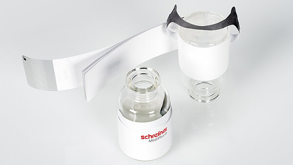 Closed and opened booklet label combined with hanger label Pharma-Tac on glass vial.